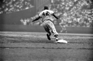 Dodger Jackie Robinson rounds first during a game against the Giants.