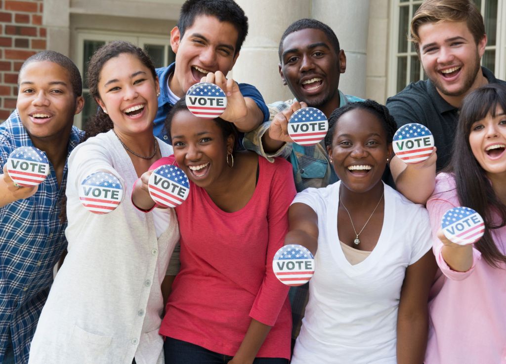 Students holding buttons at voter registration