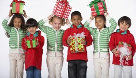 Multi-ethnic children holding Christmas gifts