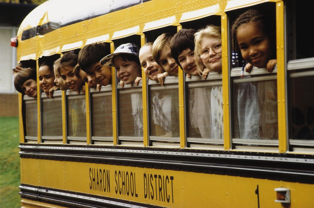 School children looking out school bus windows.