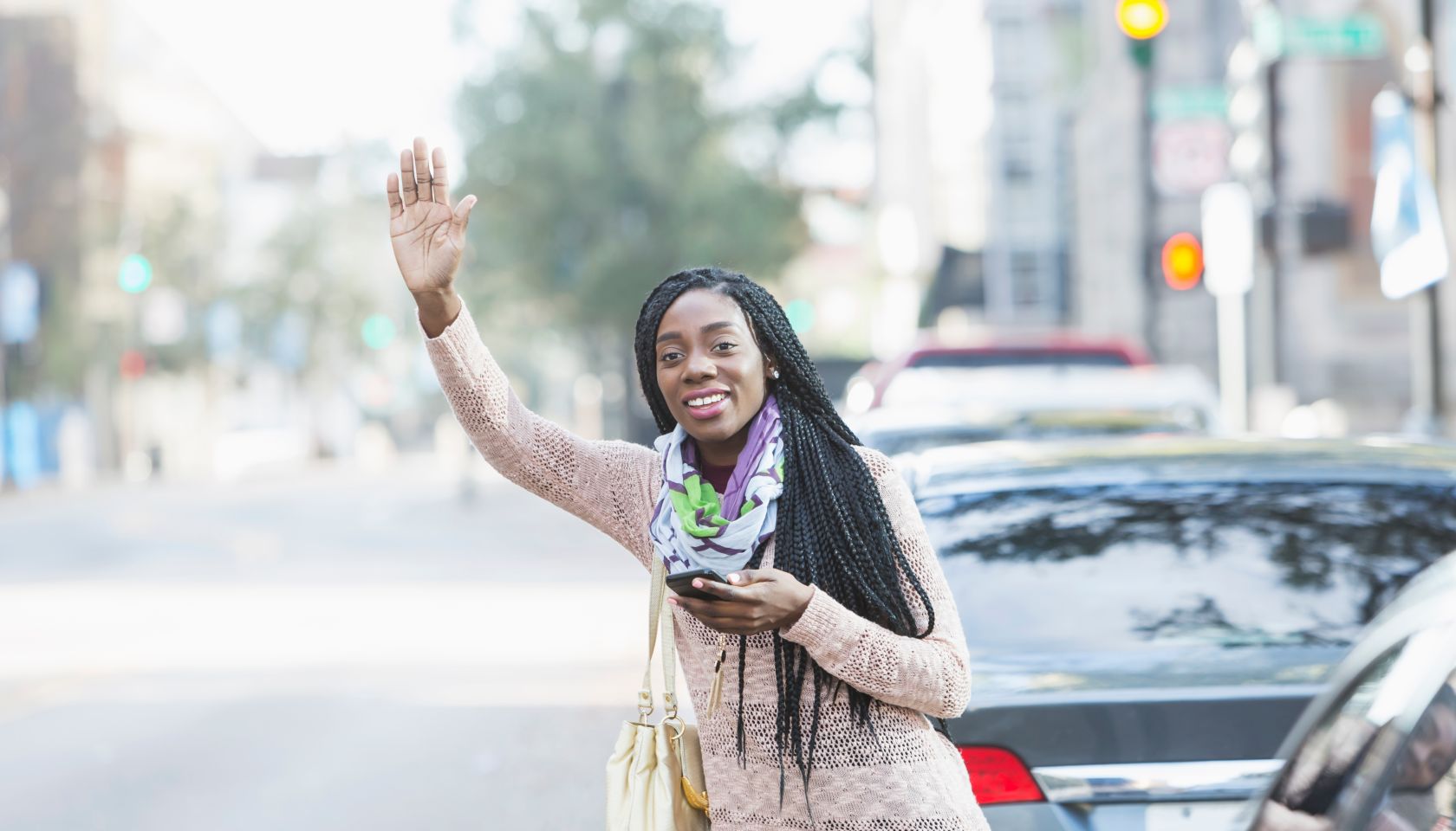 Young African-American woman in city looking for her ride
