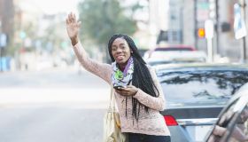 Young African-American woman in city looking for her ride