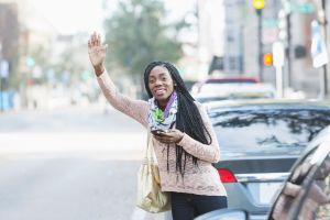Young African-American woman in city looking for her ride