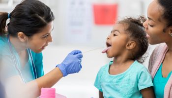 Doctor examines young African American patient