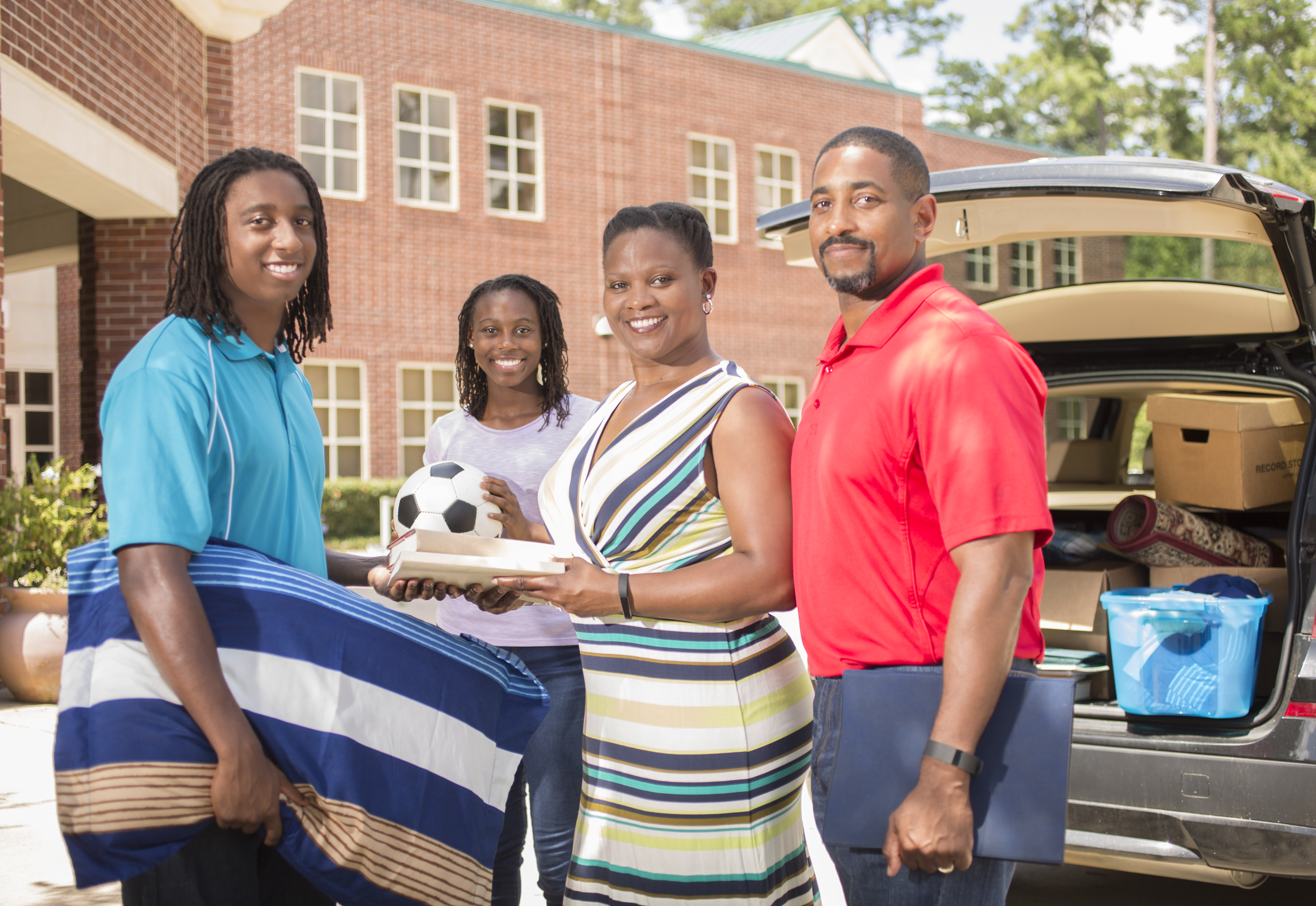 African descent teenage boy moves into college dorm.