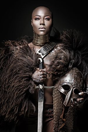 Beautiful black warrior princess holding a sword in studio shot