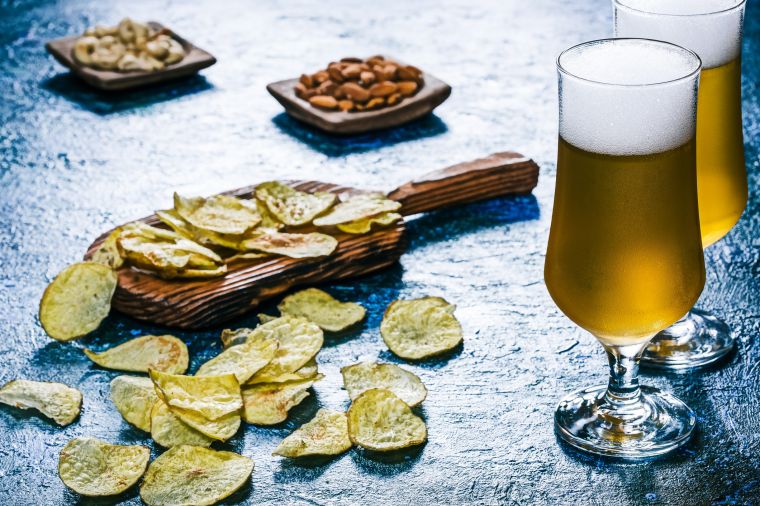 Beer and snack over glossy blue