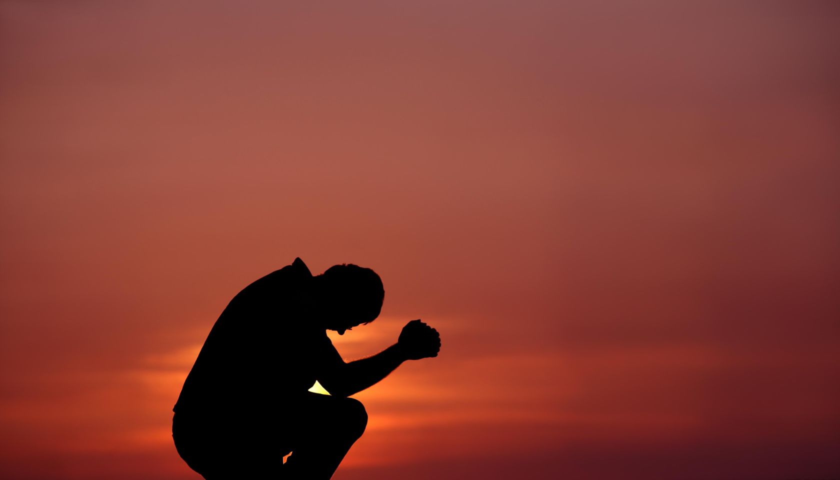 Silhouette of Man Praying at Dusk