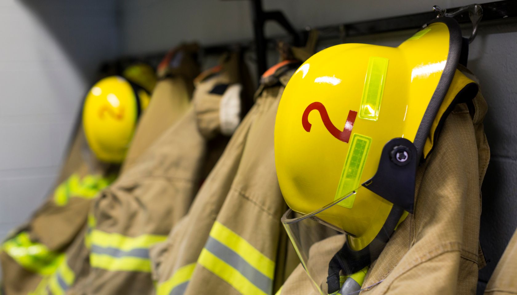 Coats and helmets of fire fighters hanging on hooks