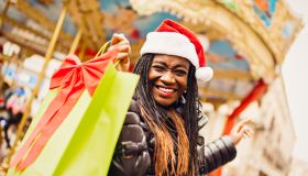 Young African woman in Santa hat with shopping bag