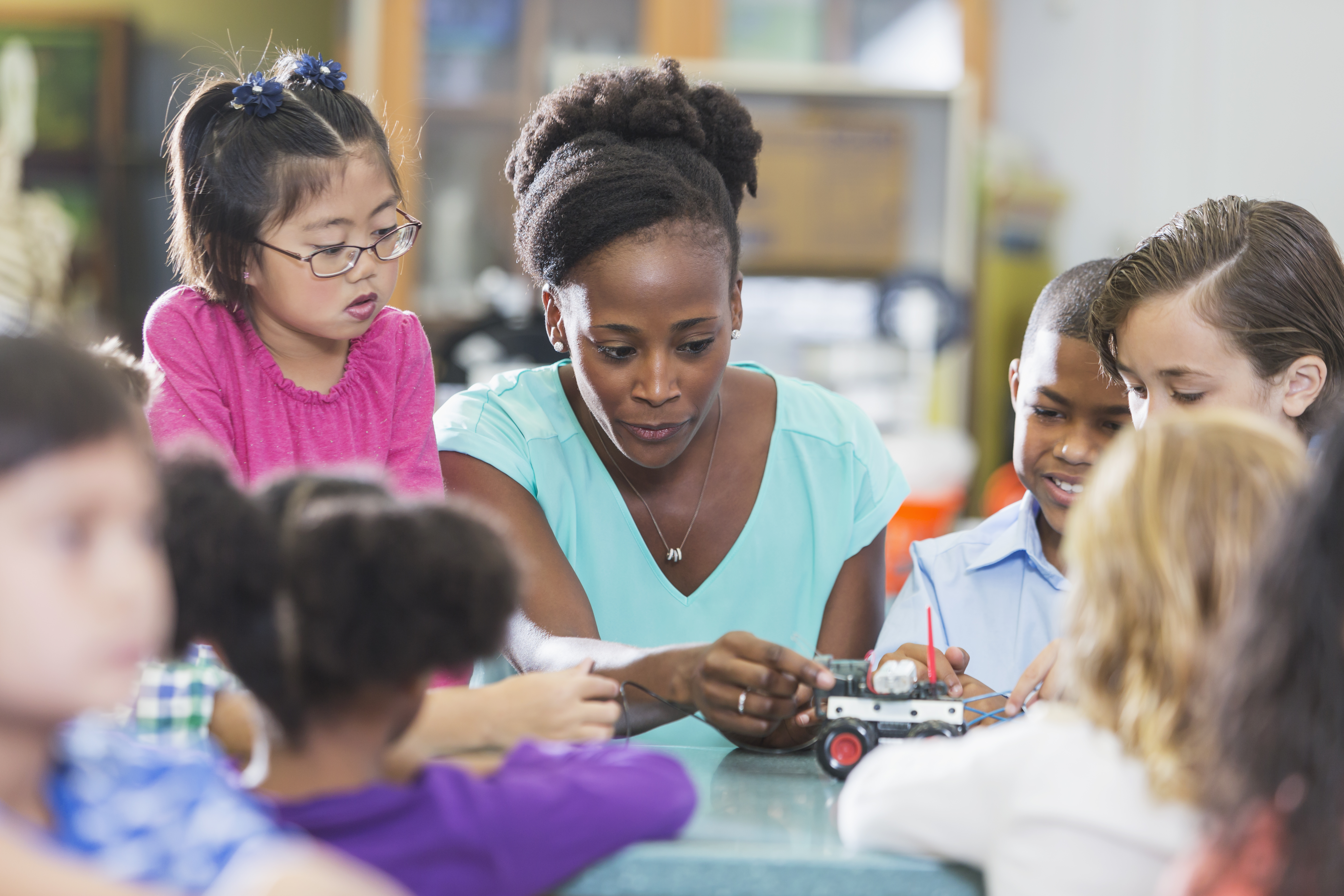 Multiracial teacher and children in science lab