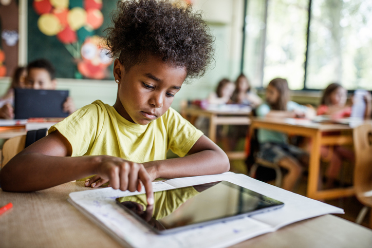 African American elementary student using touchpad on a class.