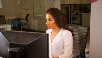 Latino Woman At Desk Side Shot