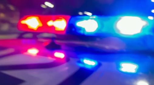 Blurred police car lights in red, blue, and white colors.
