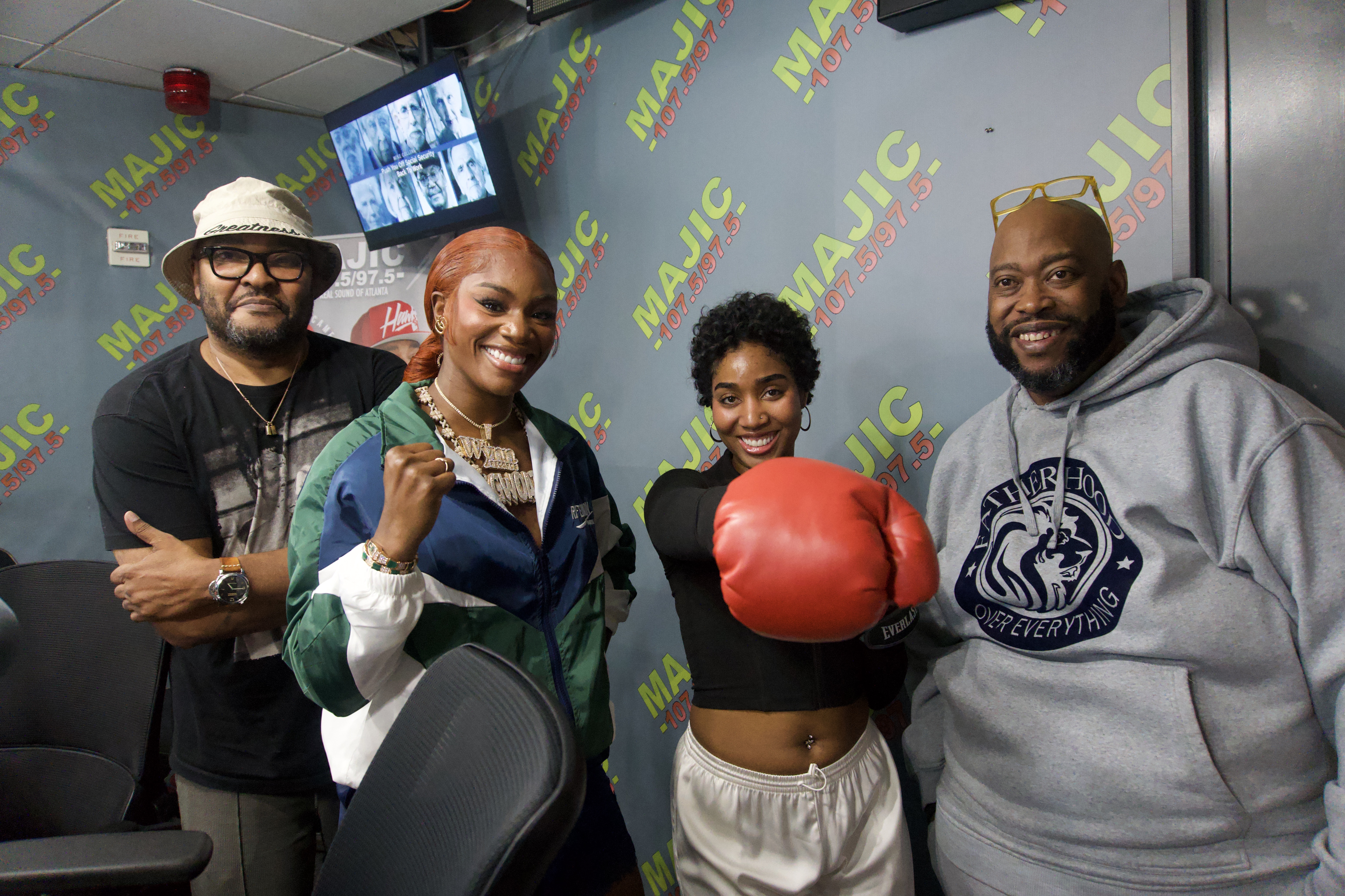 Four people posing in a room with "Magic" and "MAJIC" branding visible on the walls.